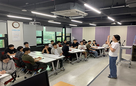 참가자들이 테이블에 앉아 발표자의 국토정보 교육 발표를 듣고 있는 강연장 모습